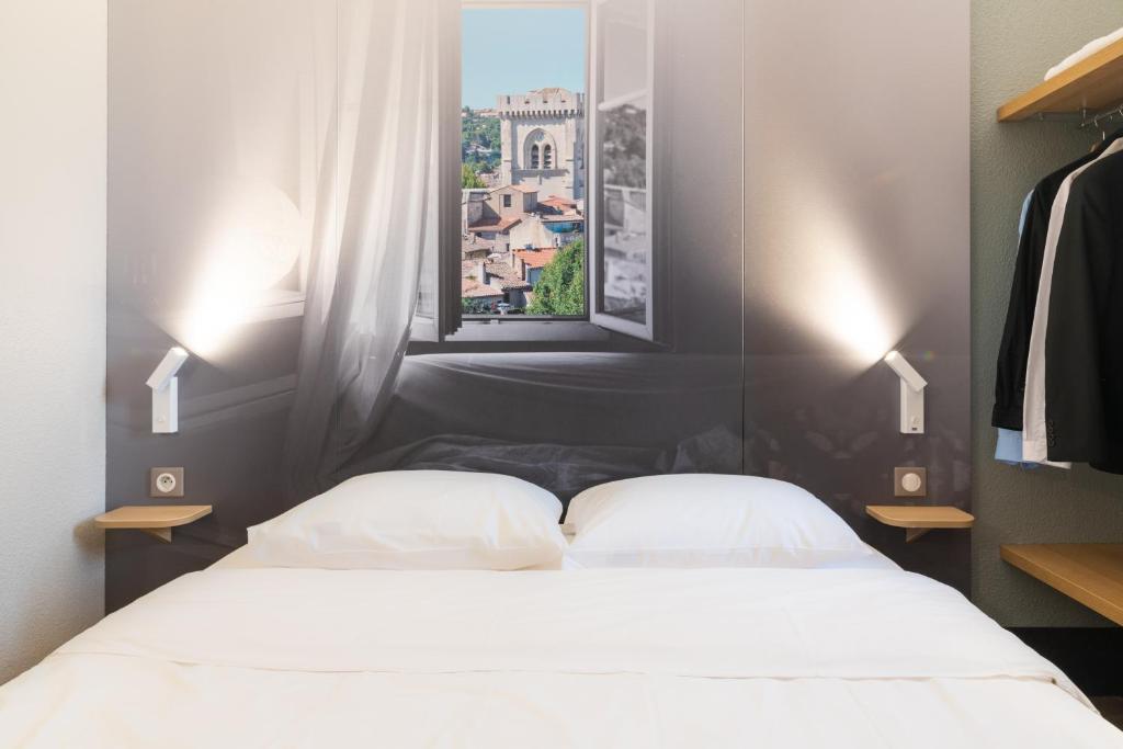 1 dormitorio con 2 camas y ventana en B&B HOTEL Avignon 2, en Le Pontet