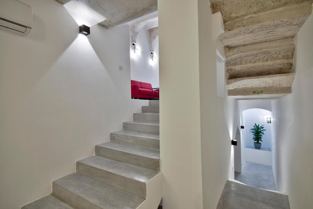 a staircase in a house with white walls and concrete stairs at Vallettastay Casa Zoe in Valletta