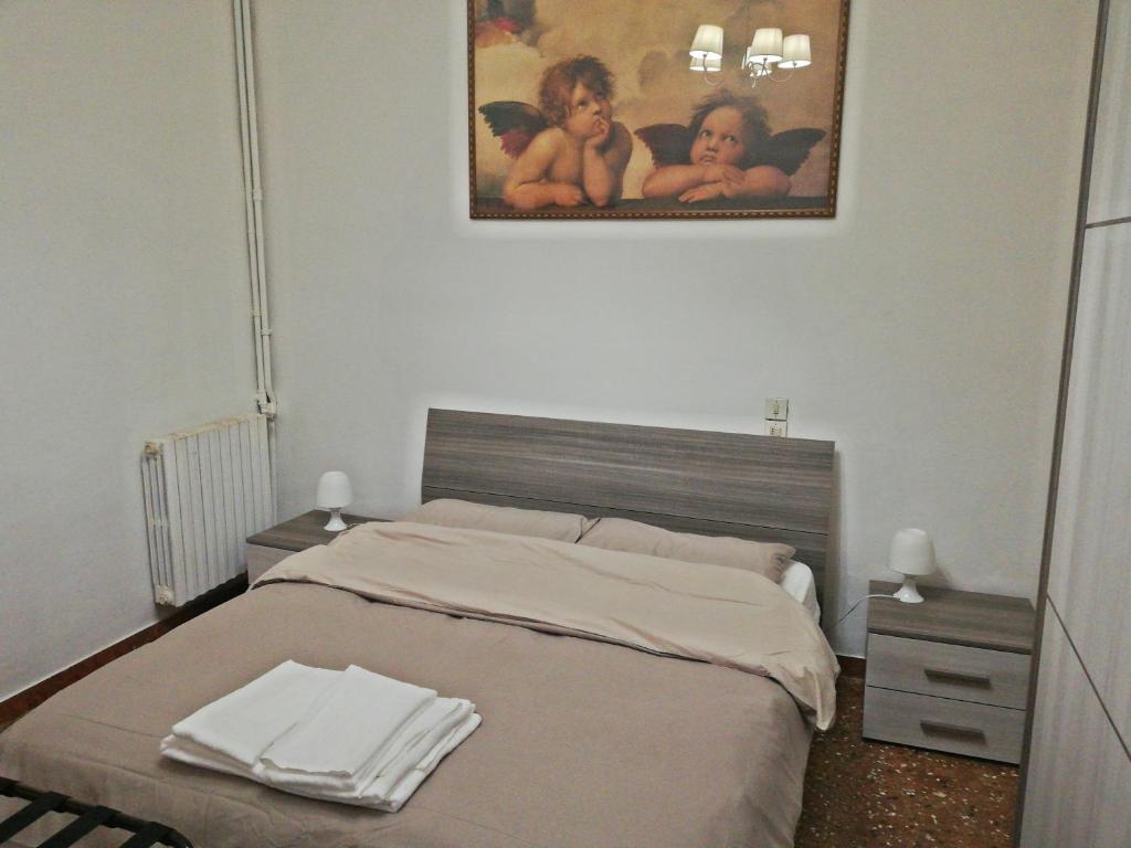 a bedroom with a bed with two tables and a painting at Balcone sul canale in Venice