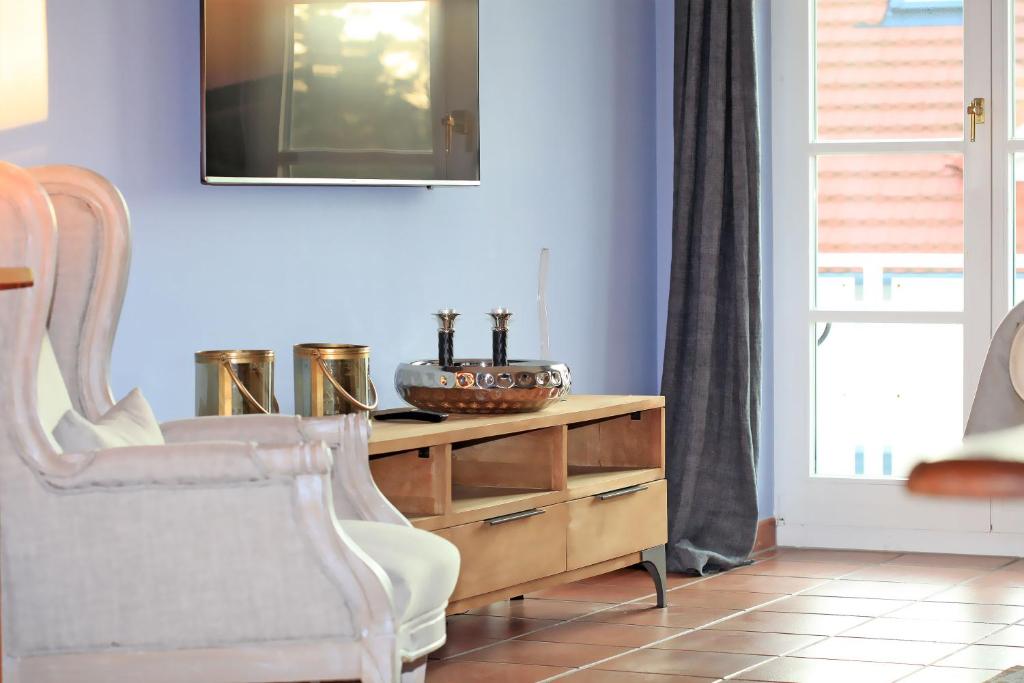 a living room with a chair and a wooden dresser at Ferienwohnung im Blauen Haus in Ahrenshoop