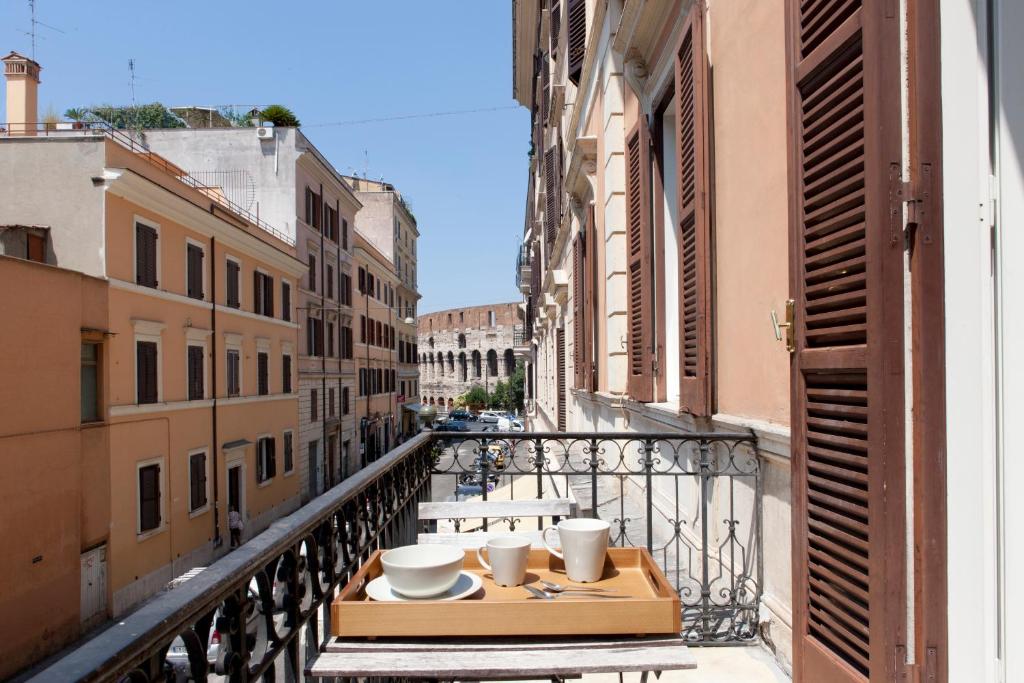 una mesa en un balcón con vistas a la calle en B&B Santi Quattro Al Colosseo, en Roma
