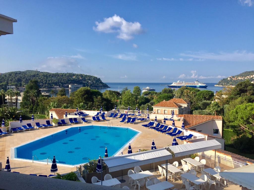 - une vue sur une piscine avec des chaises longues et un complexe dans l'établissement Nice/Villefranche, à Villefranche-sur-Mer