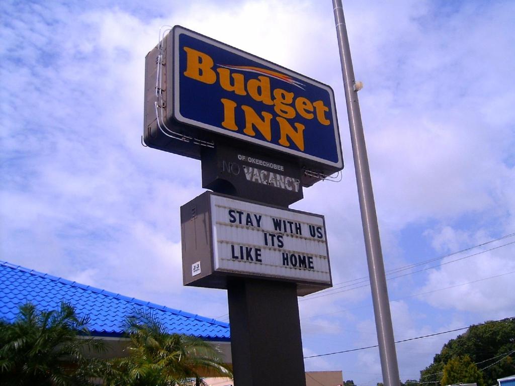 Un panneau pour une auberge de buisset sur un poteau dans l'établissement Budget Inn of Okeechobee, à Okeechobee