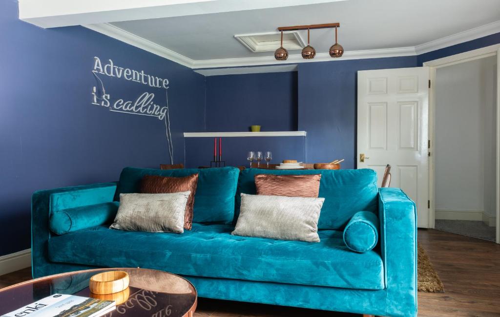 een blauwe bank in een woonkamer met een blauwe muur bij The Historic Gem - Central 3BDR Maisonette in Oxford