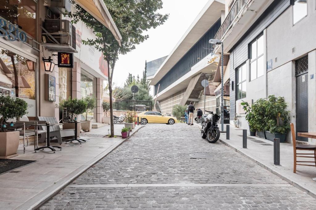 雅典的住宿－伊薩卡公寓，一条鹅卵石街道上有一辆车黄色