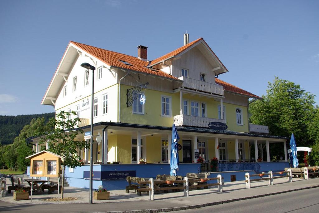 un gran edificio con bancos delante en Hotel Garni Ammergauer Hof, en Oberammergau