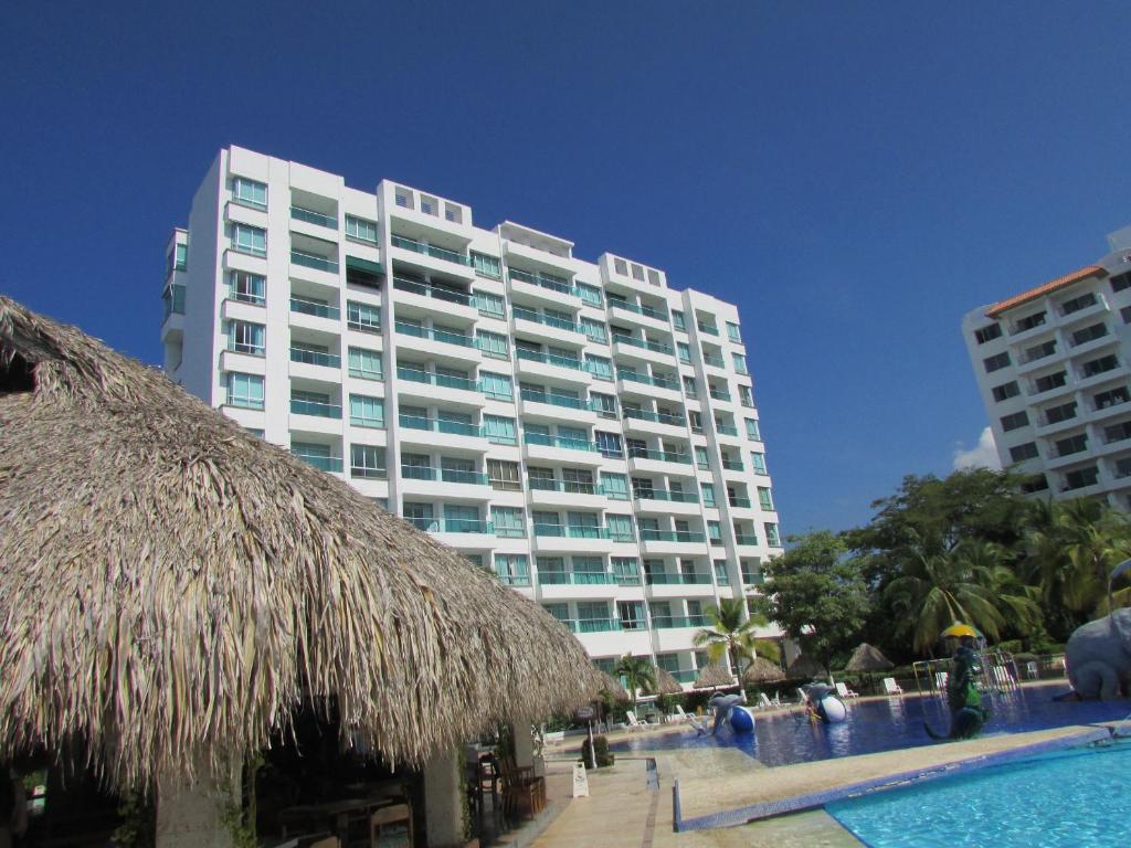 un gran edificio con una piscina frente a él en Costa Azul Suites 403 en Santa Marta