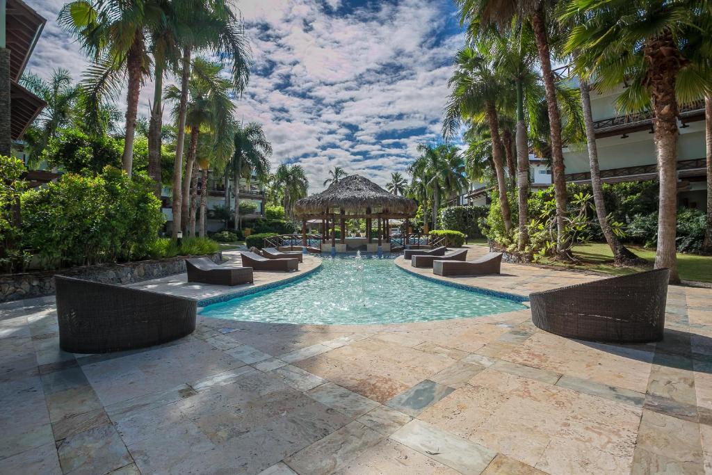 a swimming pool with a gazebo and palm trees at Balcones Beach Penthouse in Las Terrenas
