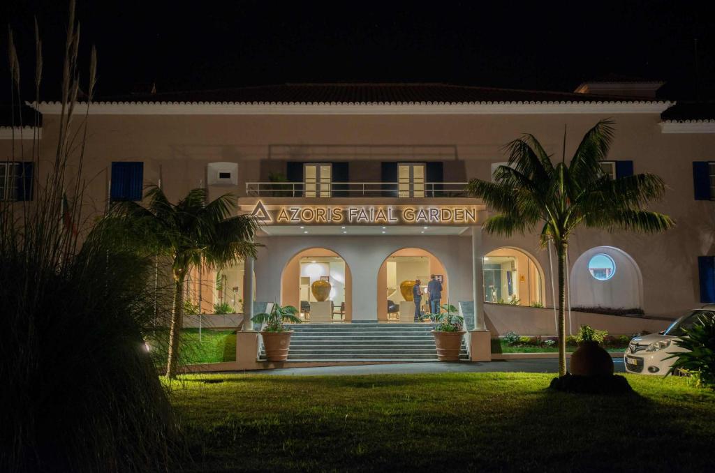 a actors rental garage at night with palm trees in front at Azoris Faial Garden – Resort Hotel in Horta