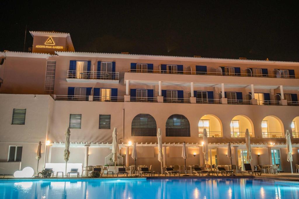 a hotel with a swimming pool in front of a building at Azoris Faial Garden – Resort Hotel in Horta