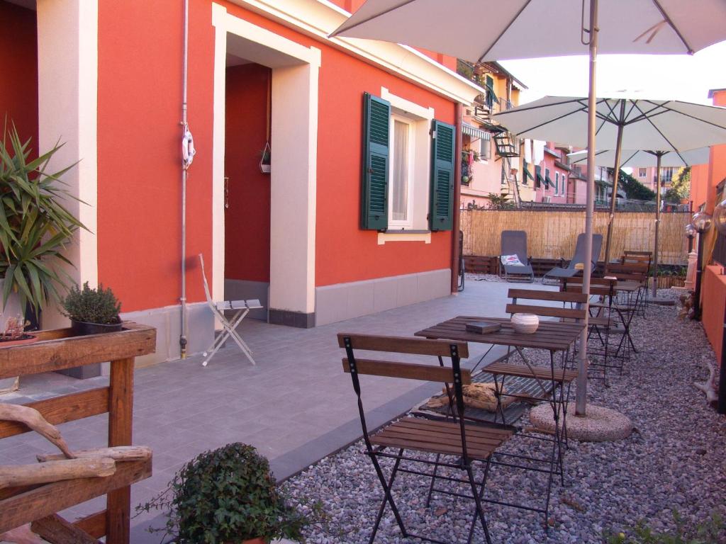 - un ensemble de tables et de chaises avec parasols sur la terrasse dans l'établissement Le Onde, à Levanto