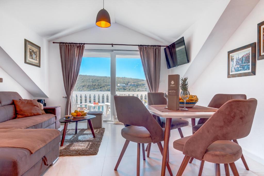 a living room with a table and a couch at Sea Oasis Apartments - Milosevic in Kotor