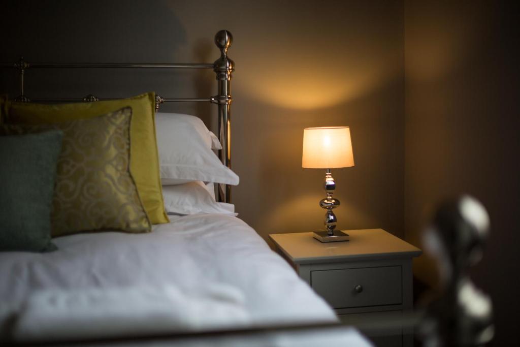 a bedroom with a bed with a lamp on a night stand at Fossgate Bridge Apartments York in York