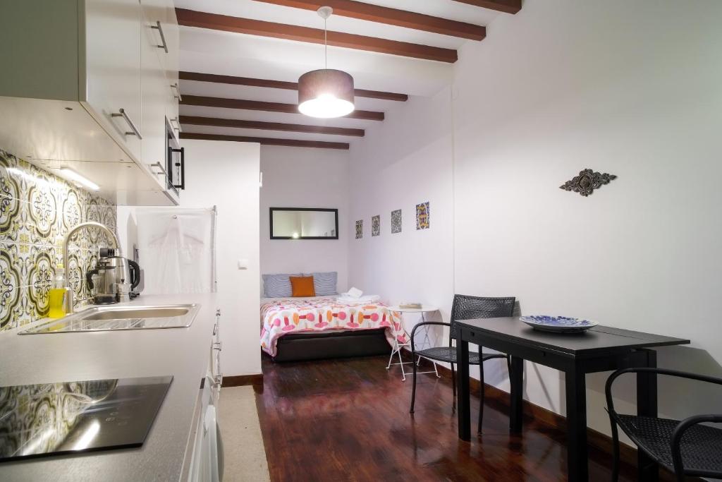 リスボンにあるSalvador Apartmentのキッチン、ダイニングルーム(テーブル、ベッド付)
