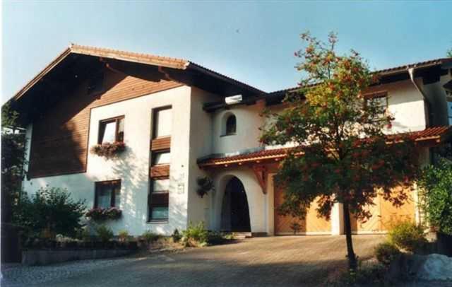 een groot wit huis met een boom ervoor bij Haus Helga in Hof bei Salzburg