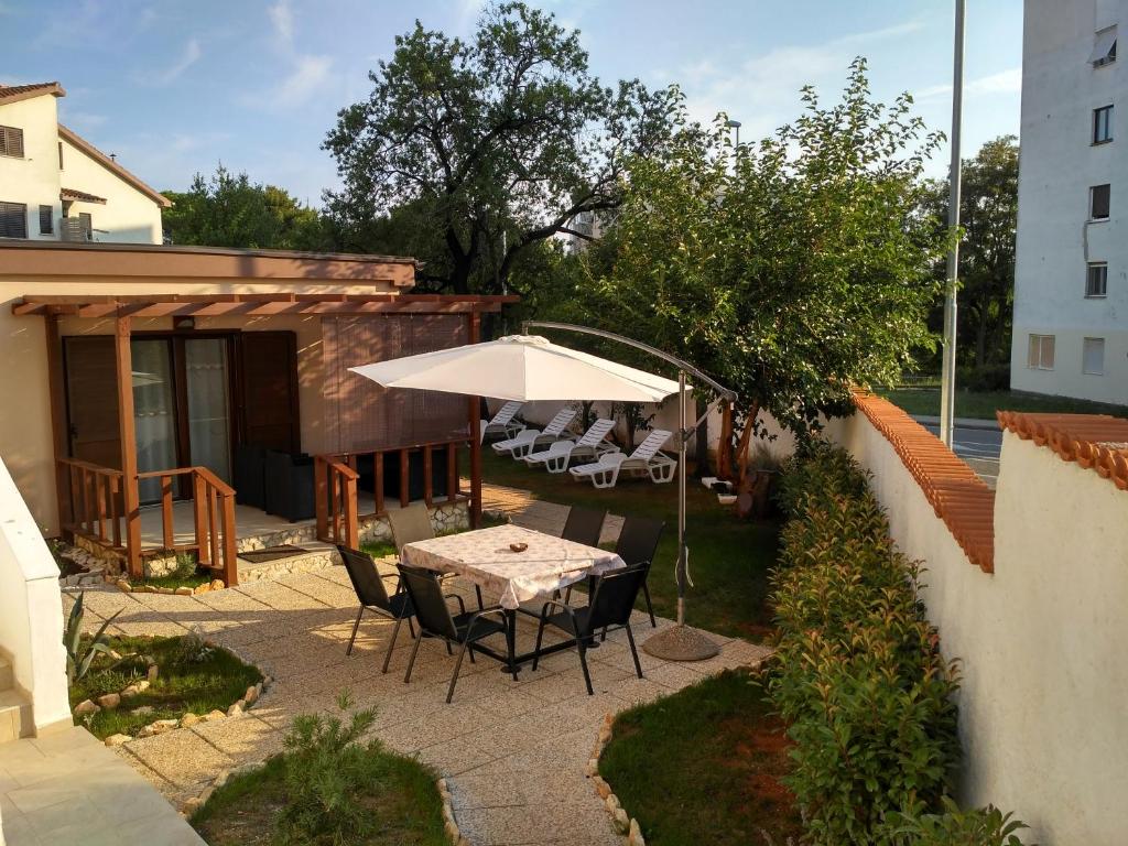 a patio with a table and an umbrella at KUĆA ZA ODMOR NATALIJA in Pula