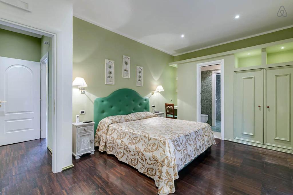 a bedroom with a large bed with a green headboard at Antico Platano in Rome