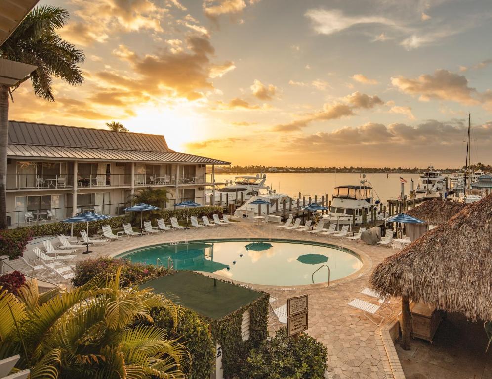 a resort with a pool and a marina at sunset at Cove Inn on Naples Bay in Naples