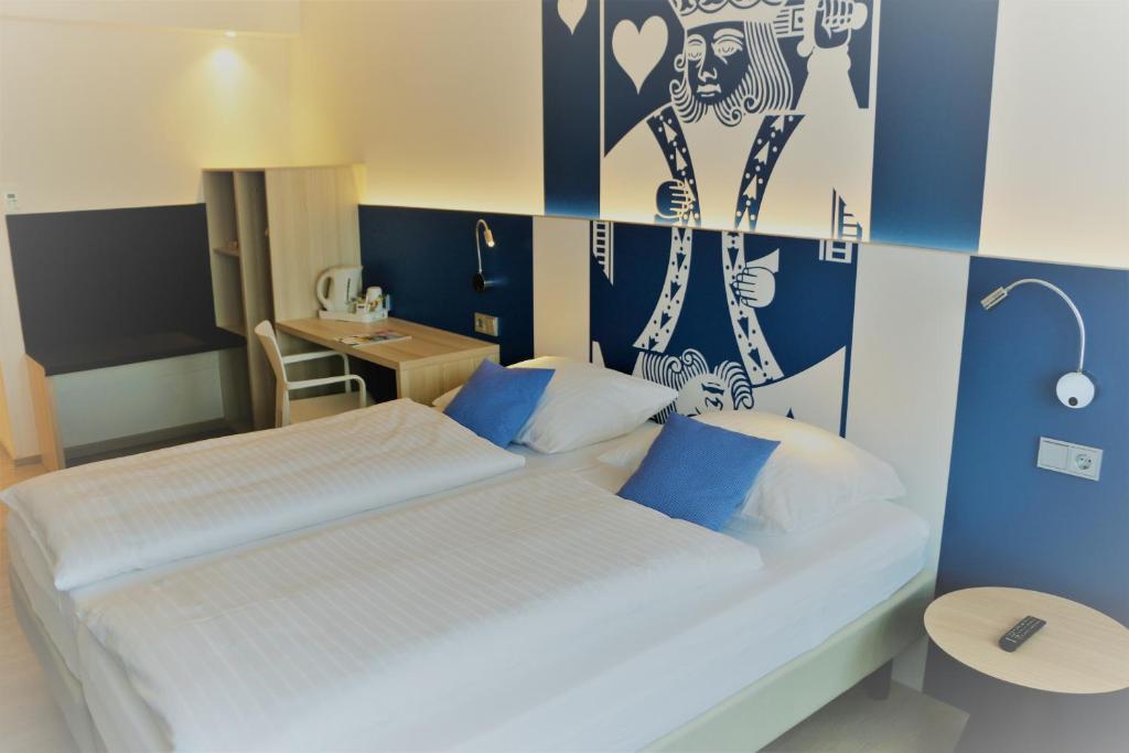 Duas camas num quarto com paredes azuis e brancas em IBB Hotel Paderborn em Paderborn