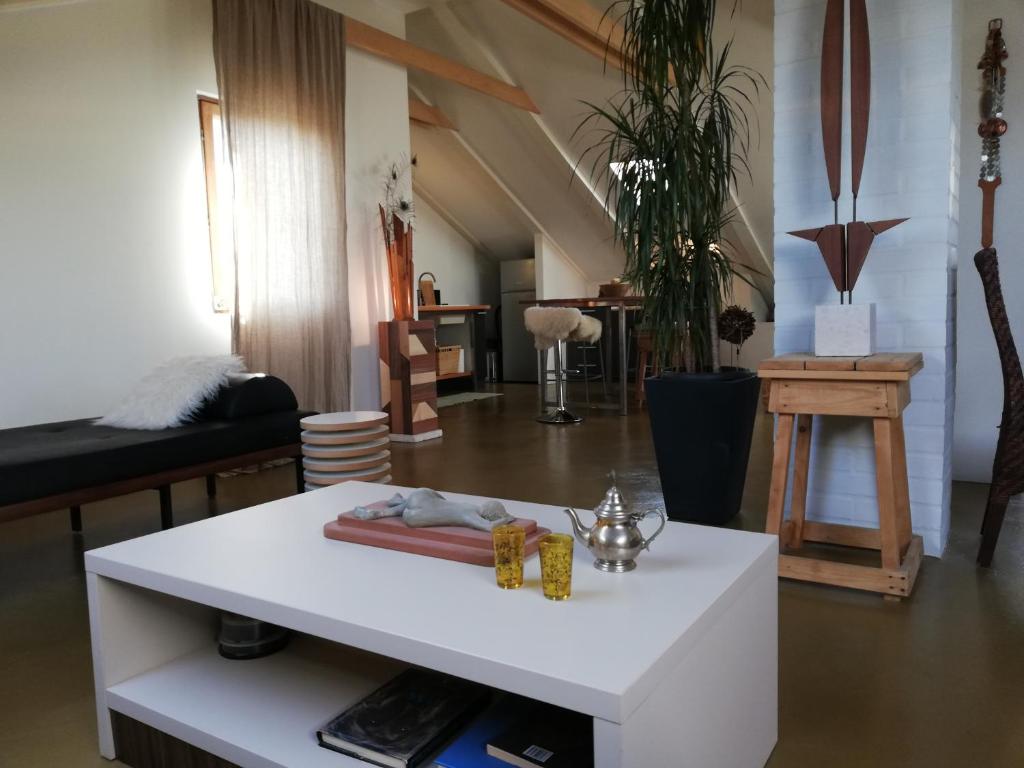 a living room with a white table and a couch at Naiadi Loft Apartment in Nerezine