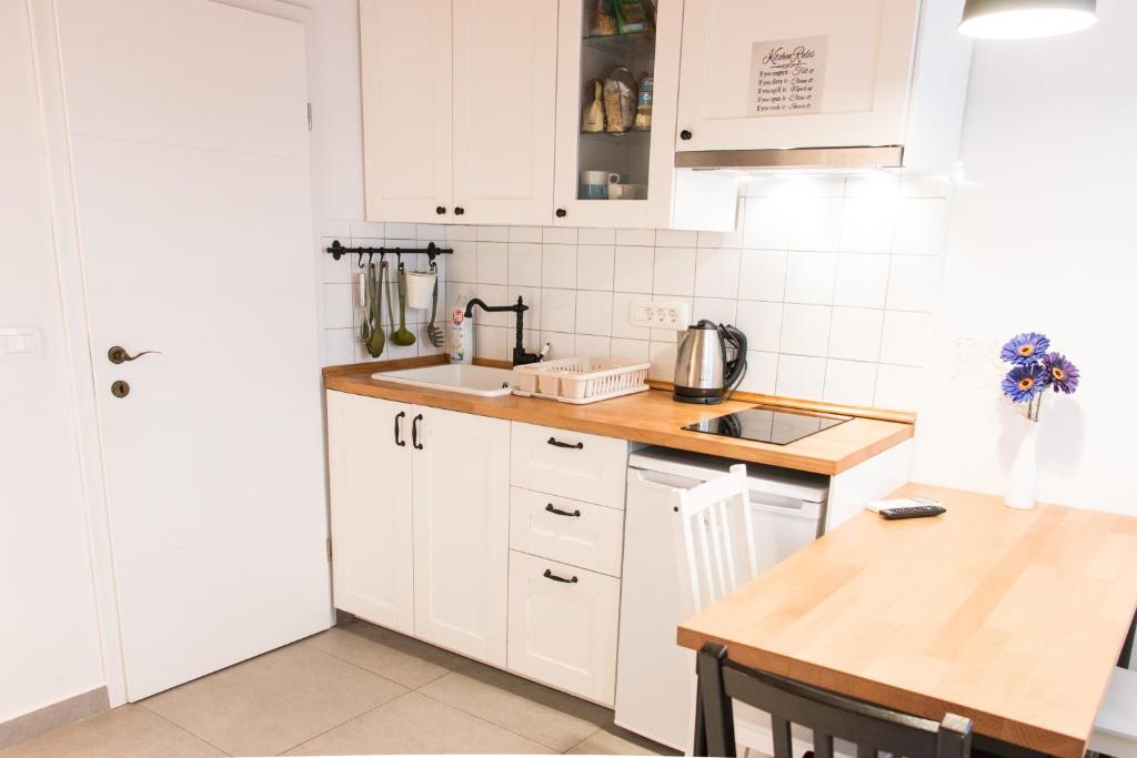 a kitchen with white cabinets and a wooden counter top at Koper2stay in Koper