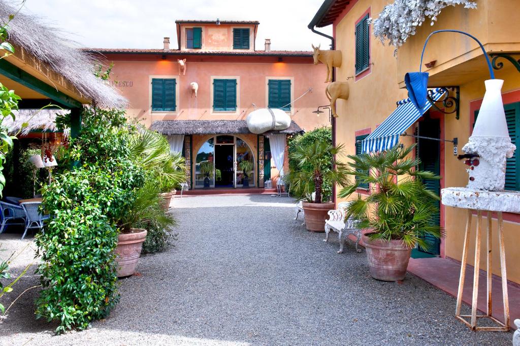 une cour avec des plantes en pot devant un bâtiment dans l'établissement Fattoria Santa Lucia Borgo alla Cantina, à San Gervasio