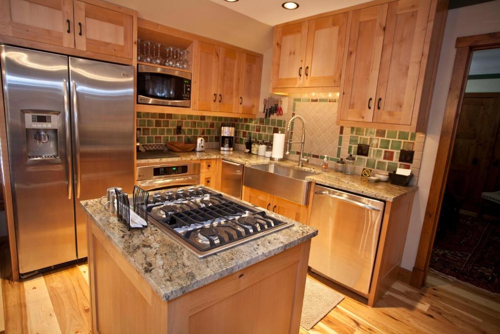 a kitchen with stainless steel appliances and wooden cabinets at Penthouse By The Gondola in Telluride