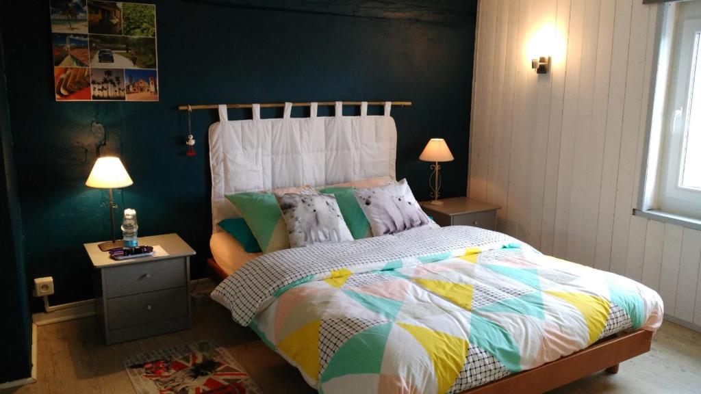 1 dormitorio con 1 cama con un edredón colorido en Chambre dans ancienne Ferme rénovée en Éteimbes