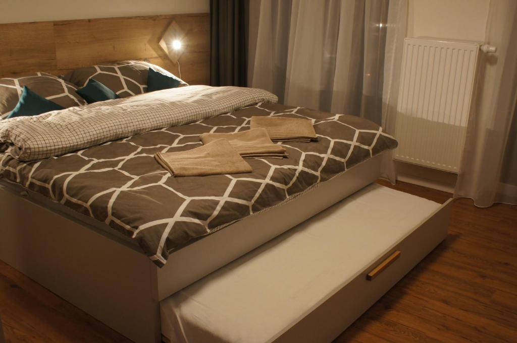 ein Bett mit einer braunen und weißen Bettdecke darauf in der Unterkunft Primo Relax in Starý Smokovec