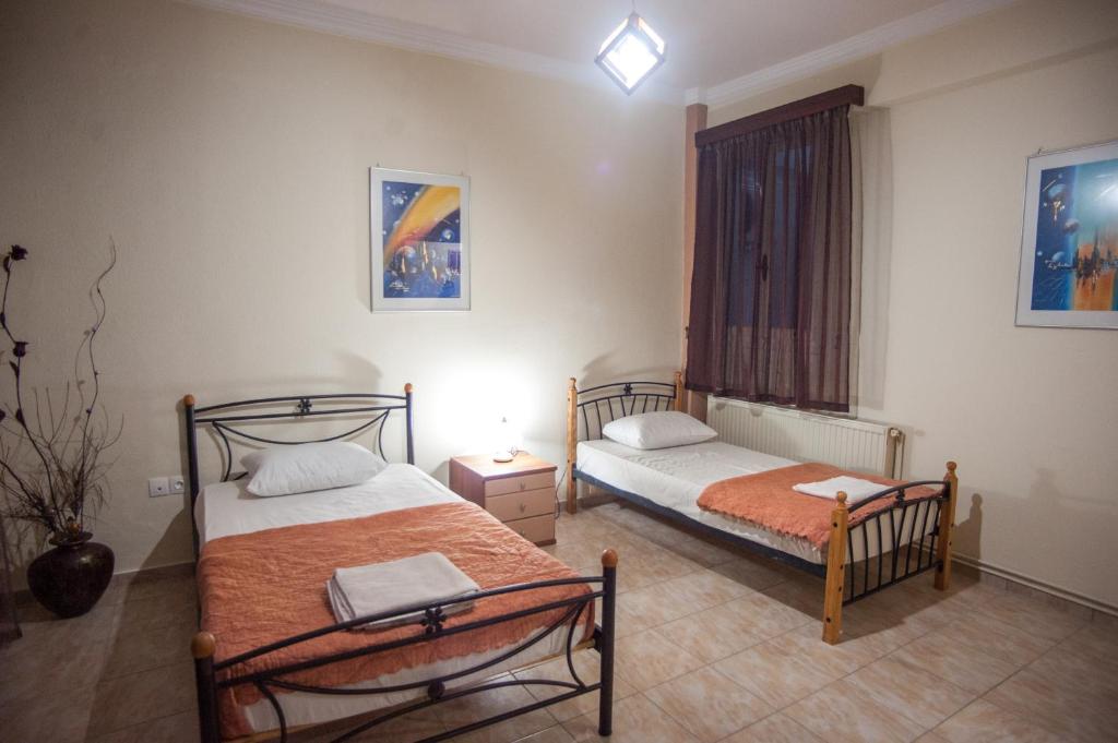 a bedroom with two beds and a window in it at Retro Chic Apartment in Argostoli