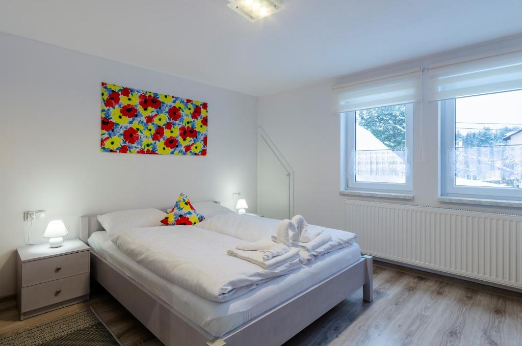 een slaapkamer met een bed met een schilderij aan de muur bij Apartament "Rodzinny zakątek" in Duszniki Zdrój