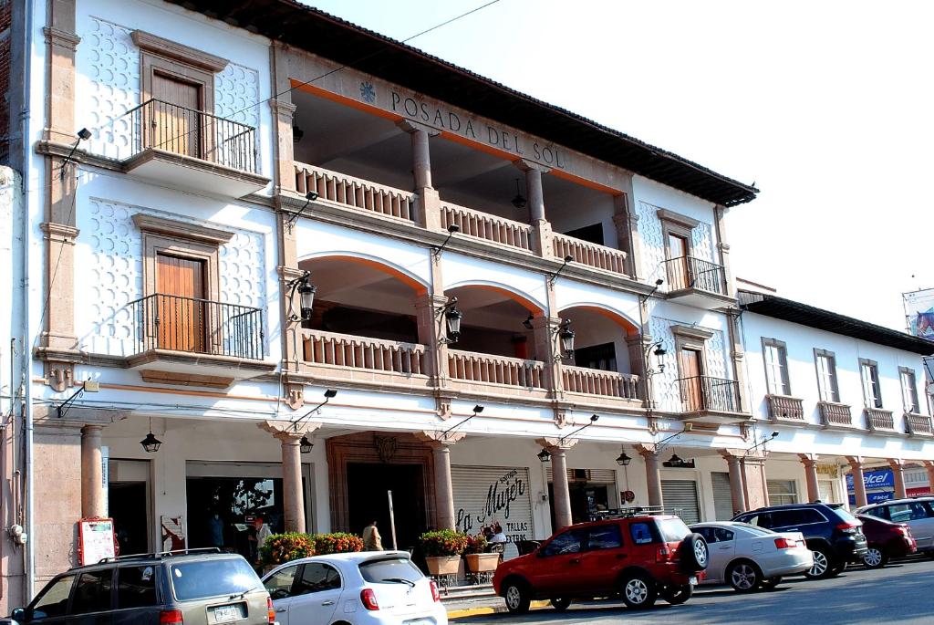 a building with cars parked in front of it at HOTEL POSADA DEL SOL in Apatzingán de la Constitución