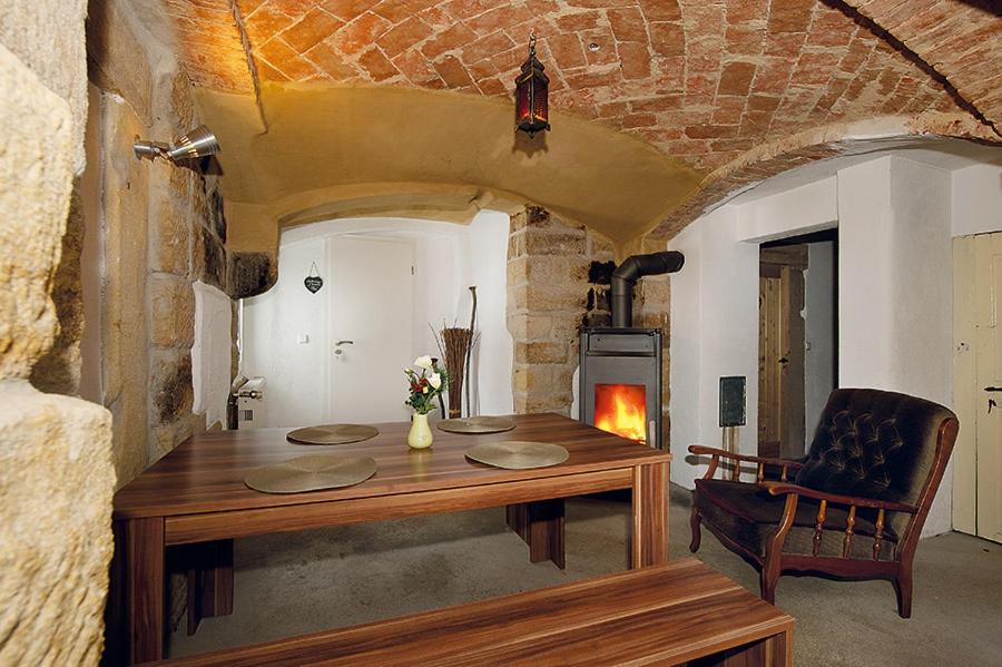 uma sala de jantar com uma mesa e uma lareira em Bergoase Hütte und Hostel Sauna Kamin Lagerfeuer em Mittelndorf