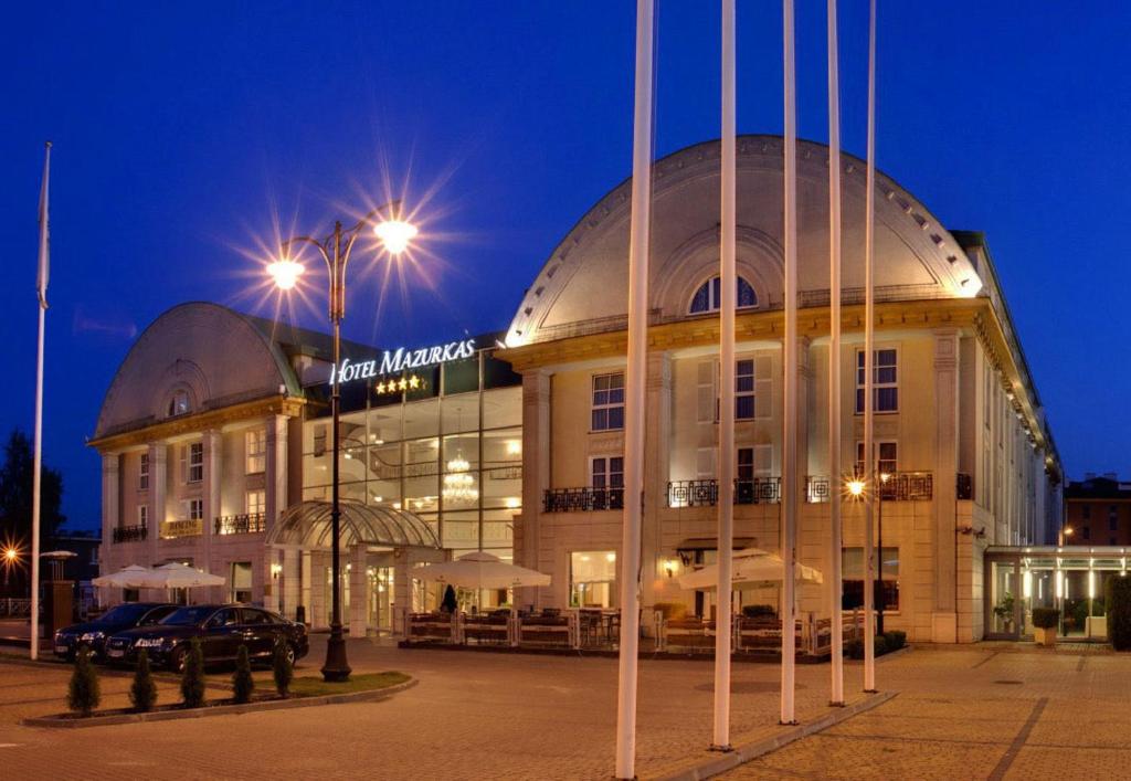 a large building with a domed building at night at Hotel Mazurkas in Ożarów Mazowiecki