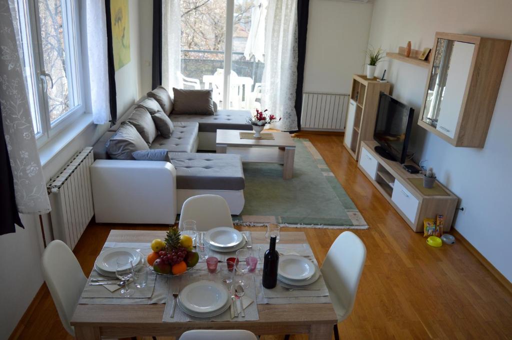 uma sala de estar com uma mesa e um sofá em Apartment Marlena em Zagreb