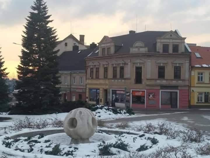 una statua nella neve davanti a un edificio di Apartmány Litvínov centrum a Litvínov