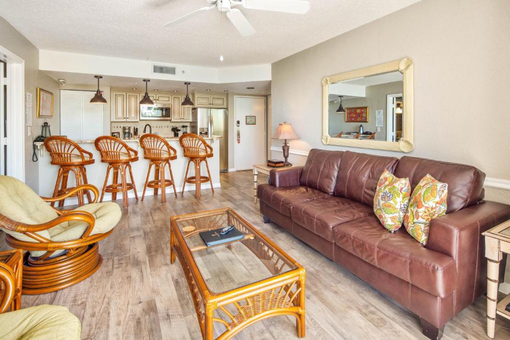 uma sala de estar com um sofá de couro castanho e cadeiras em Sunrise Suites Tahiti Suite #104 em Key West