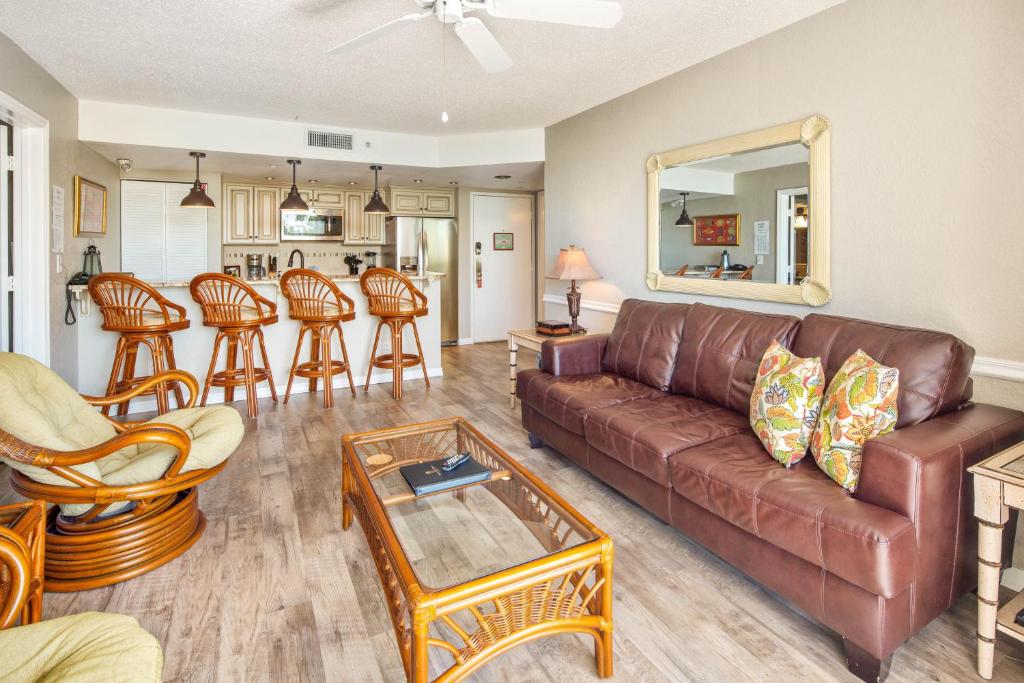 a living room with a brown leather couch and chairs at Sunrise Suites Tahiti Suite #104 in Key West