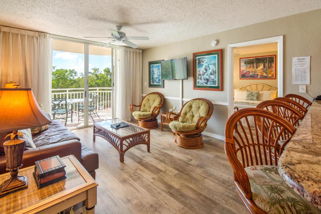 una sala de estar con un sofá y sillas en Sunrise Suites Tahiti Suite #104, en Key West