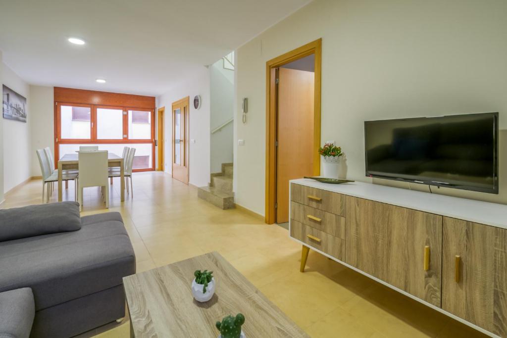 a living room with a couch and a flat screen tv at Vivalidays Urban Tossa House in Tossa de Mar