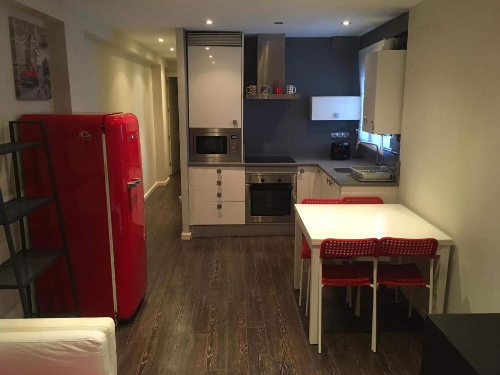 cocina con nevera roja, mesa y sillas en Apartamento Manuela Sancho, en Zaragoza