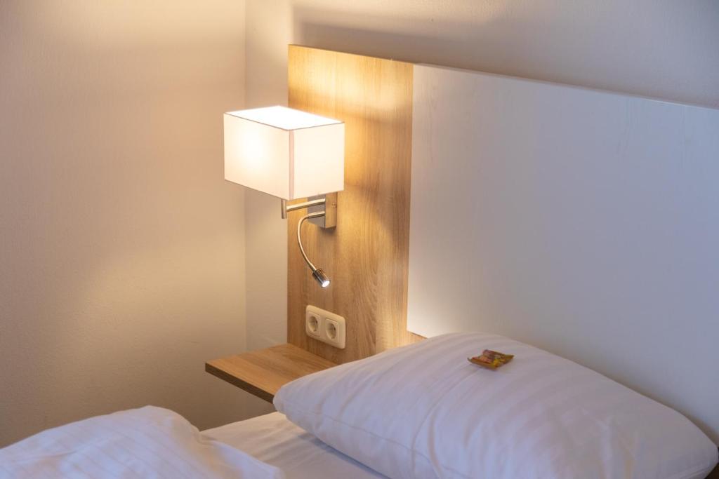 Postel nebo postele na pokoji v ubytování Heeren's Hotel Garni