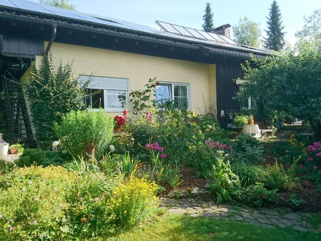 einen Garten vor einem Haus mit Blumen in der Unterkunft Landhaus Bernecker, Bay.W. in Rinchnach