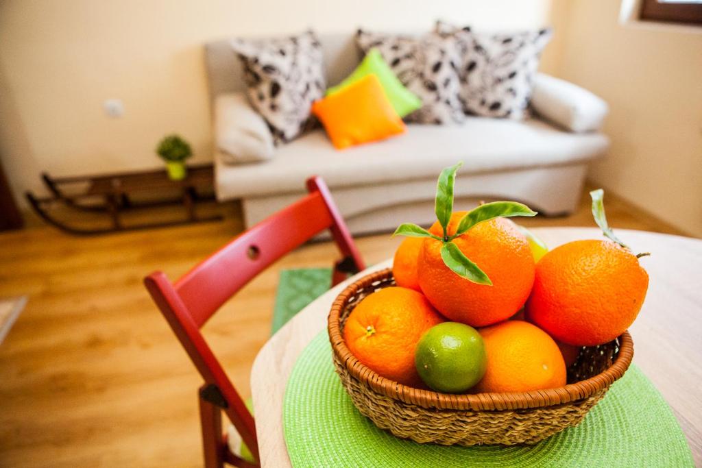 un panier d'oranges sur une table dans le salon dans l'établissement Green Orange Apartment, à Bansko