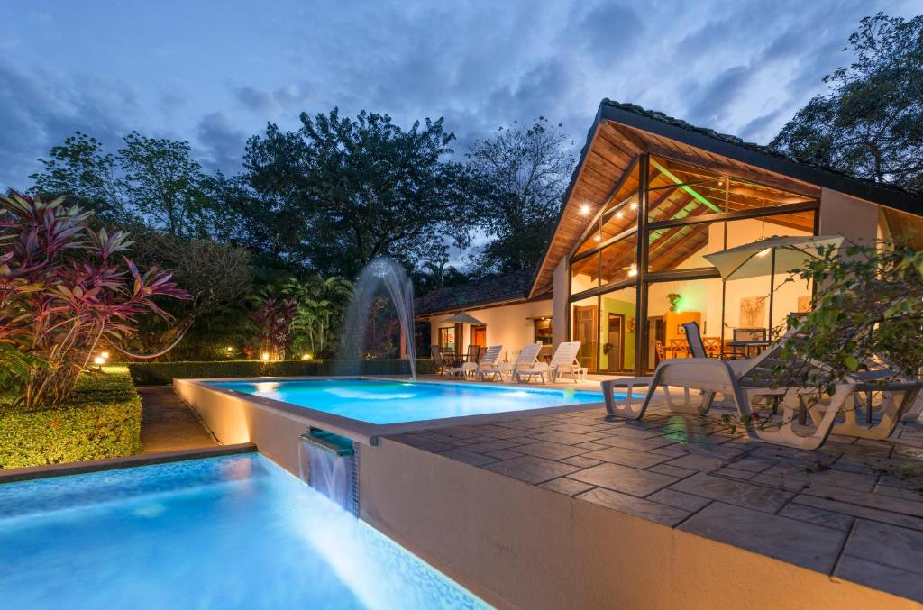 a swimming pool in front of a house at Leyenda Boutique Hotel & Spa in Sámara