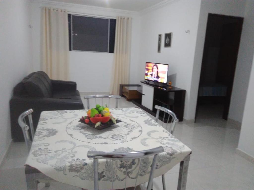 a living room with a table with a bowl of fruit on it at Ótimo apto Praia Bessa in João Pessoa