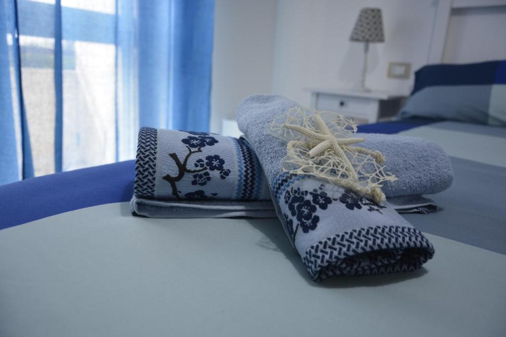 Una cama con toallas y calcetines encima. en "A Livanti" B&B, en Marzamemi