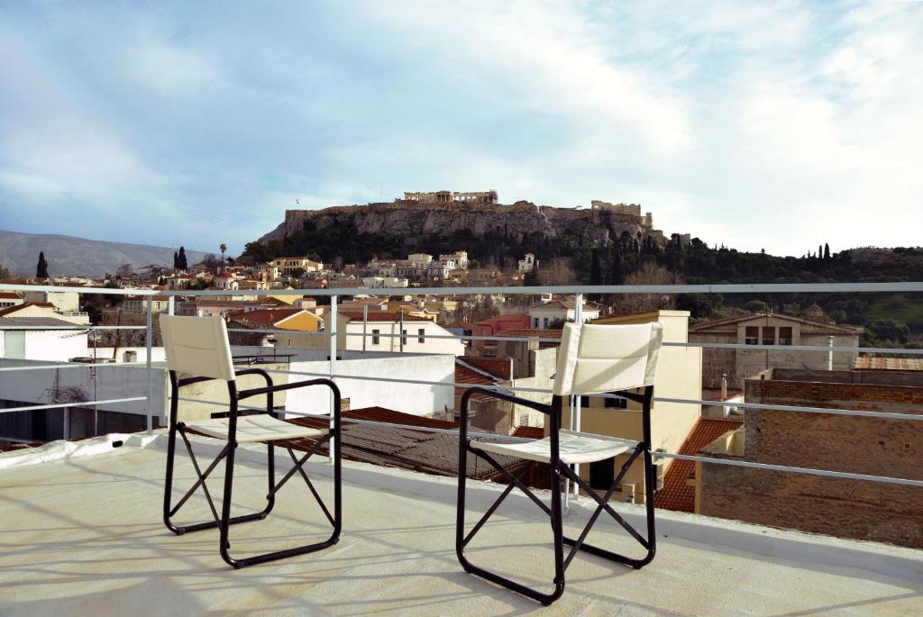 two chairs sitting on top of a roof at Apartment with Rooftop Terrace & Acropolis View in Athens