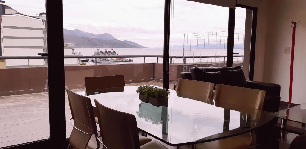 a dining room table with chairs and a view of the ocean at Ushuaia Flat I in Ushuaia