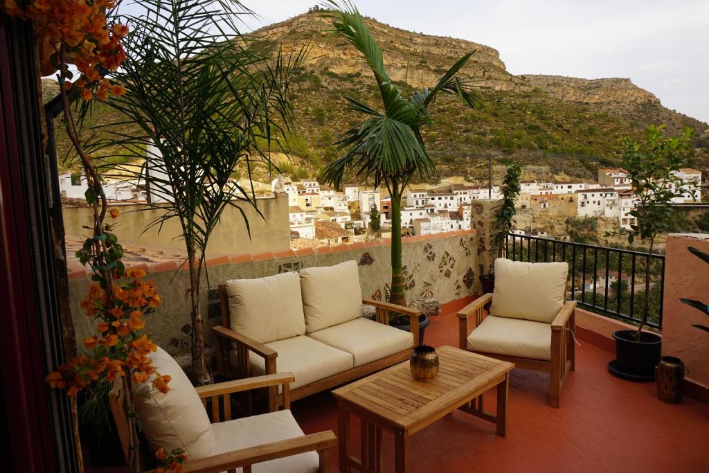 a balcony with chairs and a table and a view of a city at CASA DEL ARTE casa rural in Chulilla